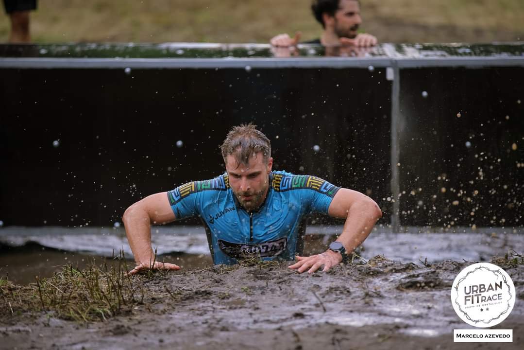 OCR athlete comming out of a mud lake in a race